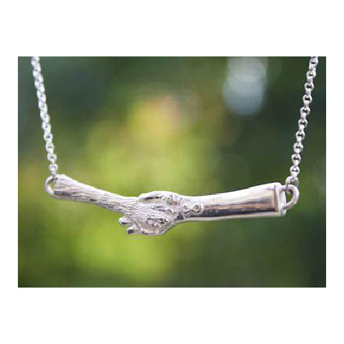 The Touched Necklace in Sterling Silver Infinity Symbol on wrist paw in hand